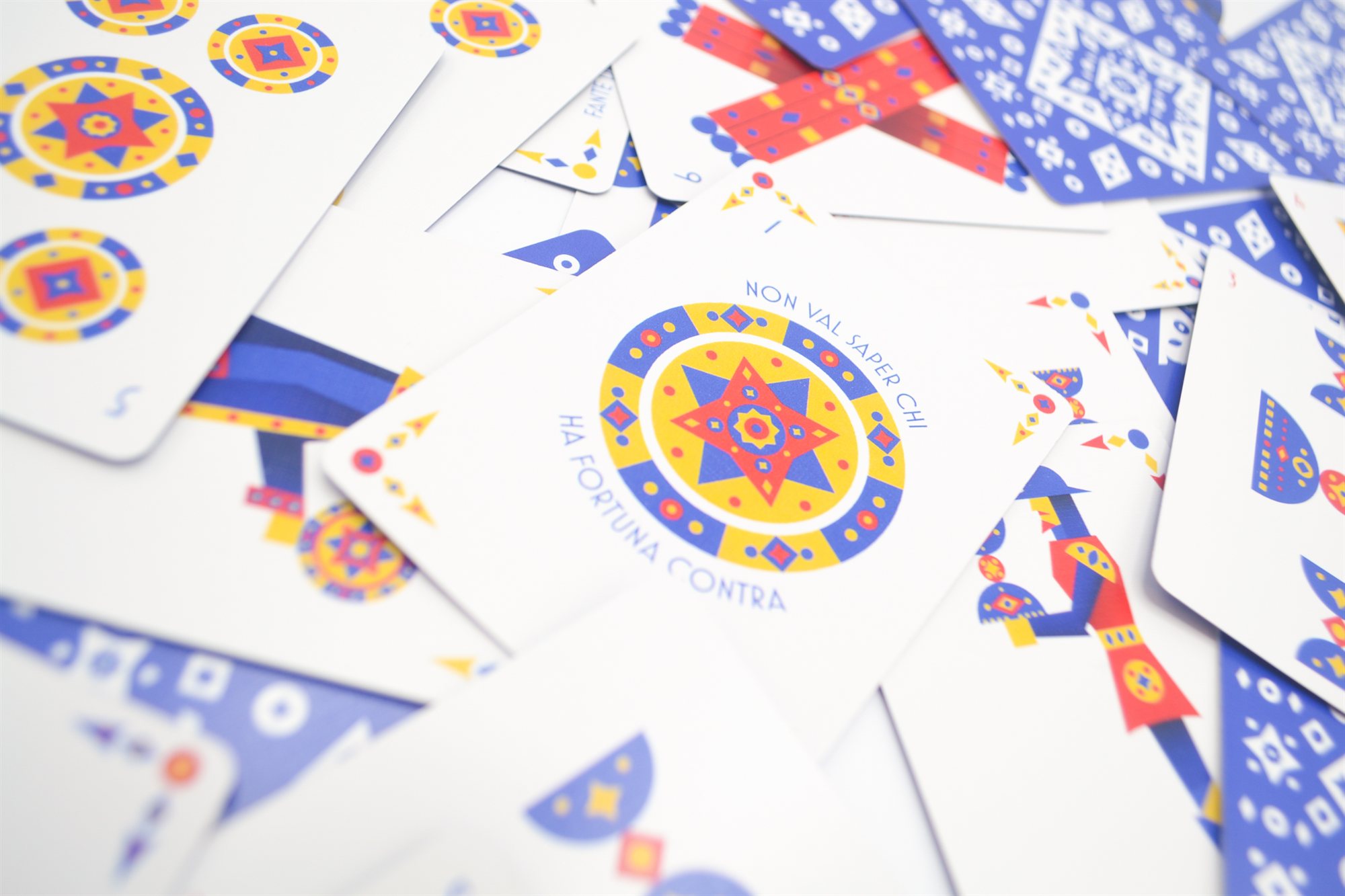 Scattered cards including the five of coins and the ace of coins printed with the motto 'Non val saper chi ha fortuna contra'