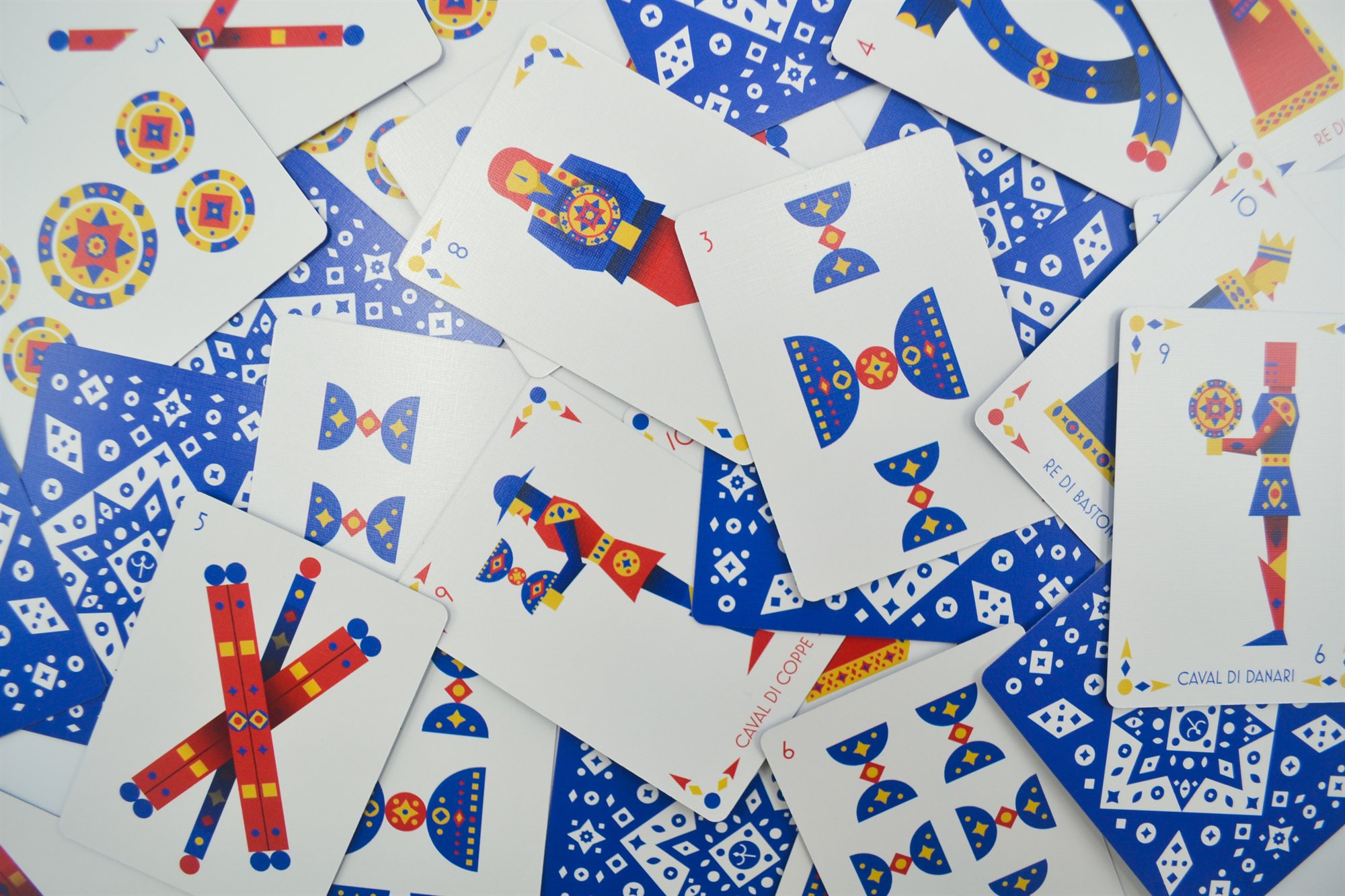 A pile of number and face cards from the cups and batons suits, including the King of Batons and Knight of Coins
