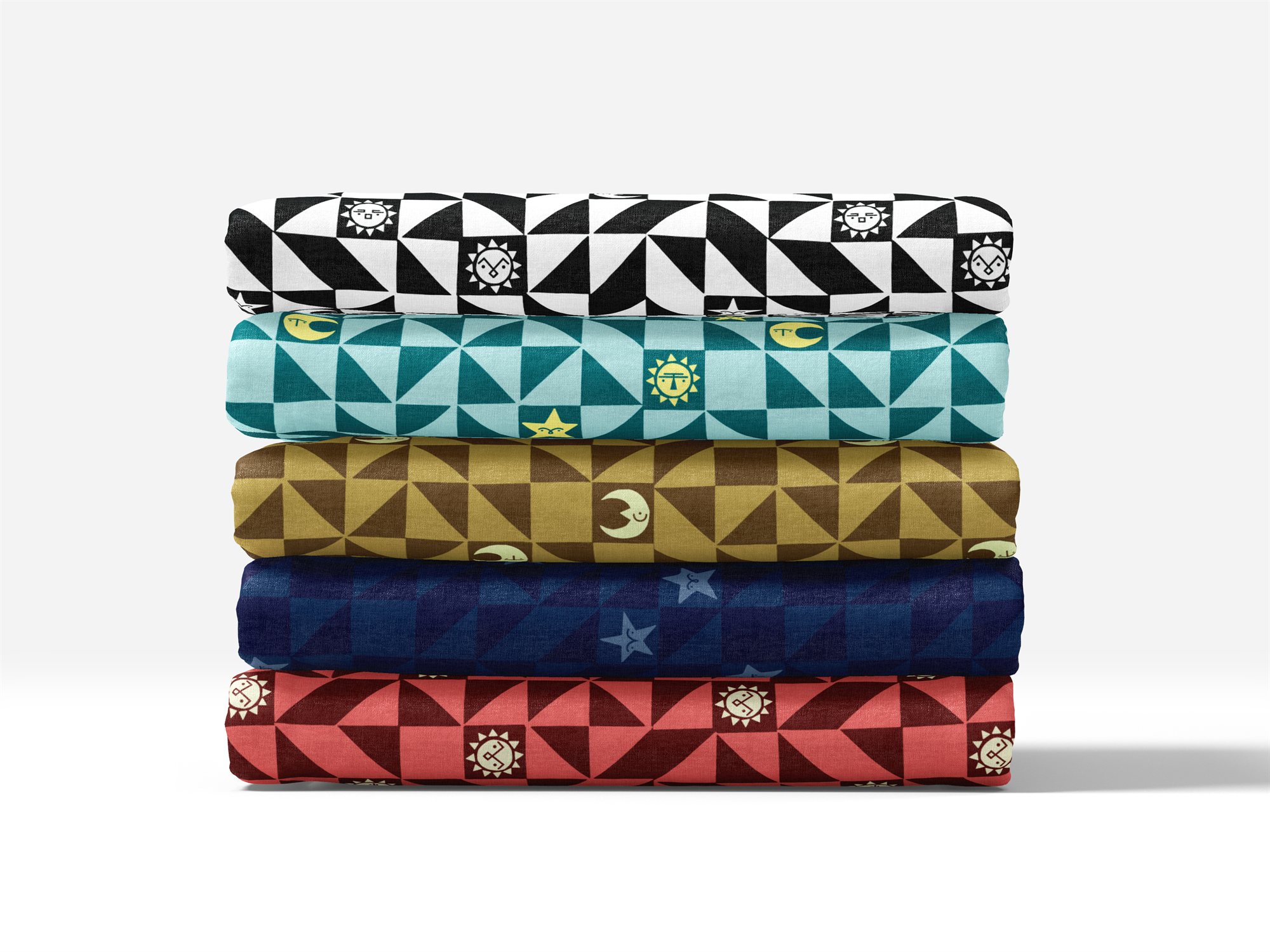 A stack of five folded fabric bolts in different colorways — black and white, teal, mustard, navy, and coral — each printed with the same grumpy sun, moon, and star pattern