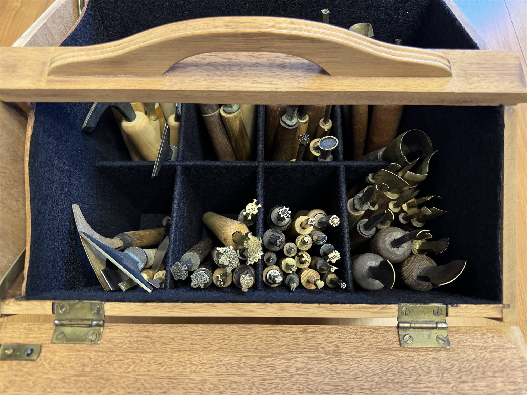 The refinished wooden sewing box closed, showing its dovetailed sides and carved carrying handle