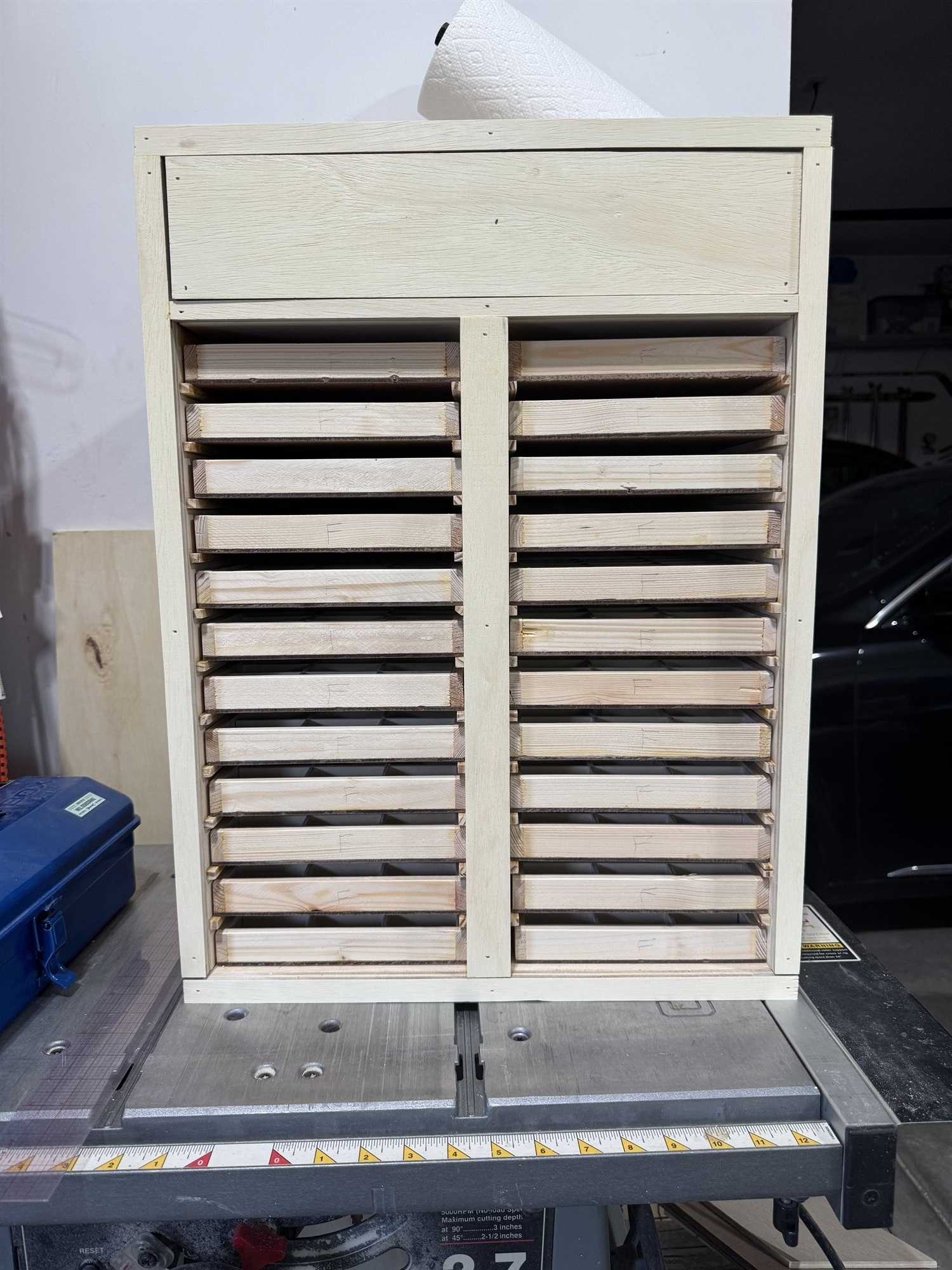 A case tray partway through assembly, notched divider strips slotted together to form the grid of compartments
