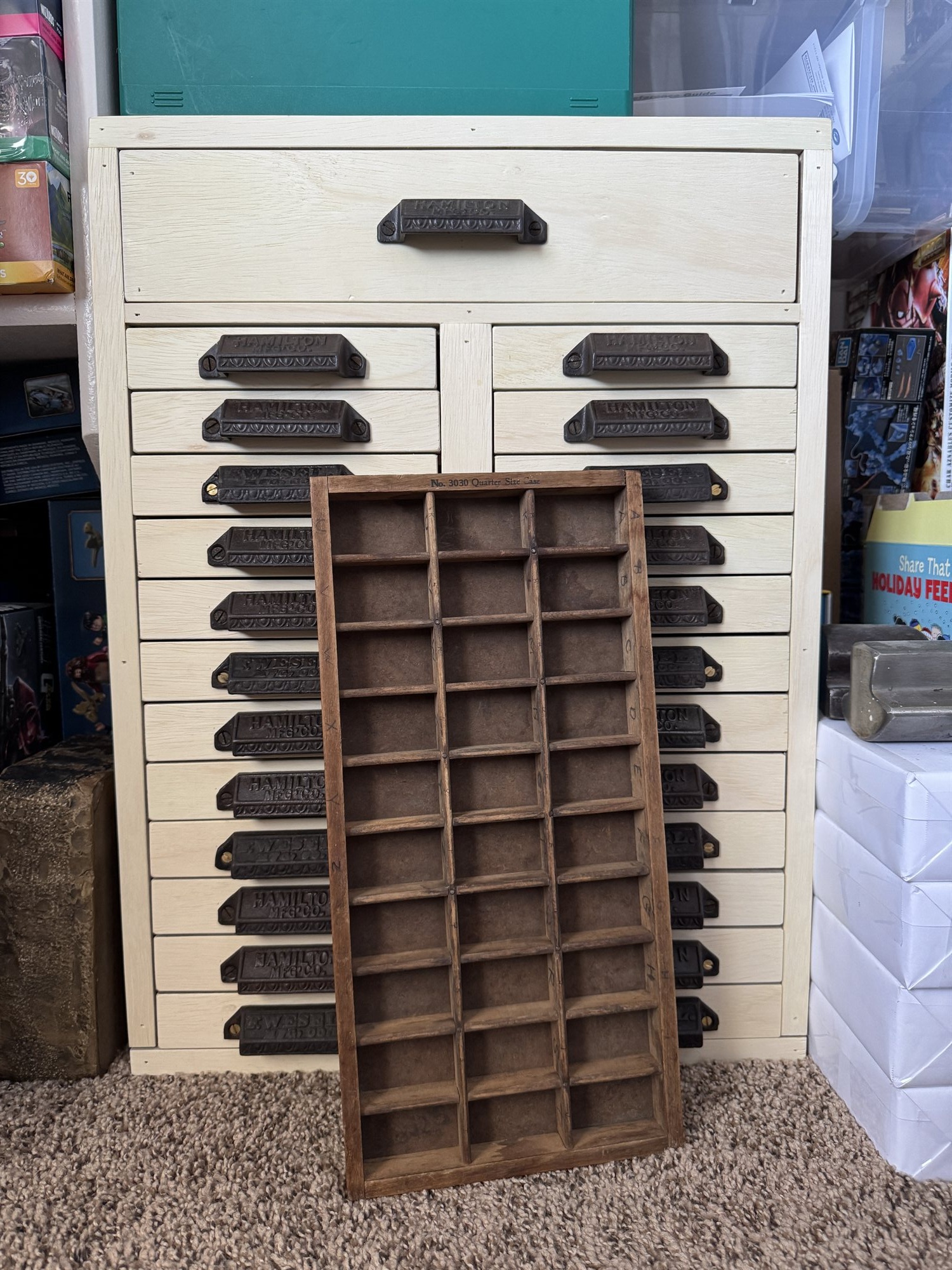 The cabinet with one case drawer pulled halfway out, an antique Hamilton No. 3030 Quarter Size Case resting on top as the sizing reference for the new trays